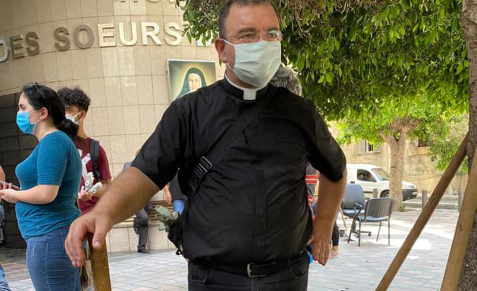 priest and other people wearing masks and cleaning up